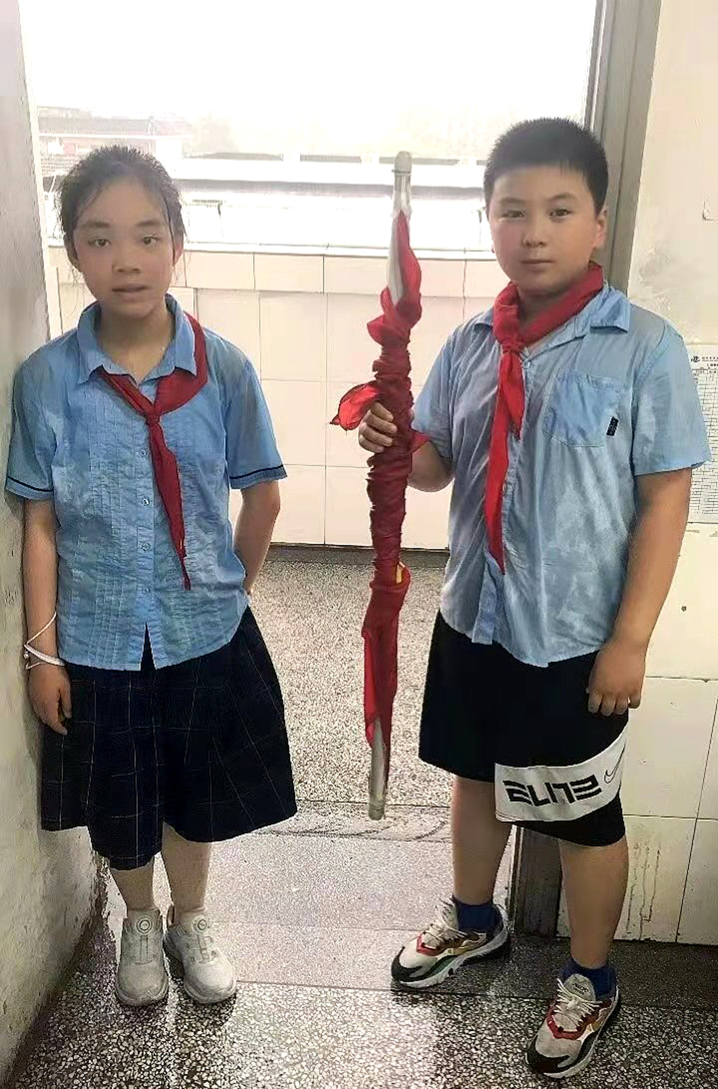 好样的!扬州育才实验学校两少年暴雨中收国旗