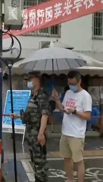 上海中考首日降雨 送考家长默默为执勤武警撑伞