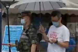 上海中考首日降雨 送考家长默默为执勤武警撑伞